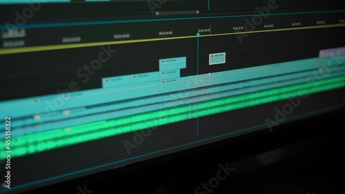 Video editing process montage in professional program closeup. Software interface for edit graphics for vlog or television broadcast. Videographer working at computer with sound, photo and video image