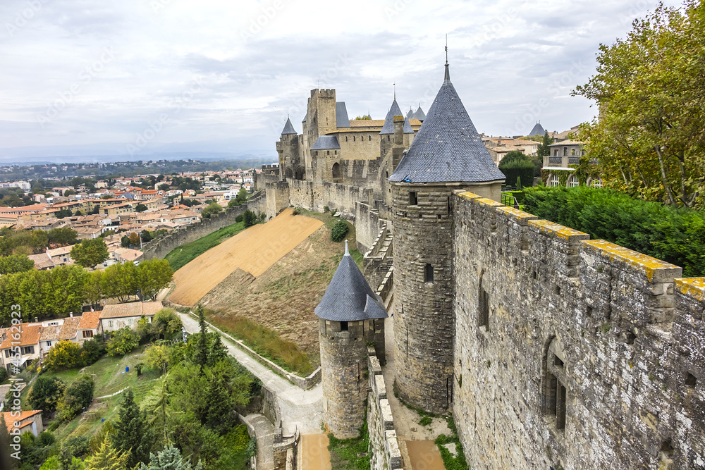 Fragments of outer wall (13th century) and towers of the Carcassonne medieval citadel on a hill on right bank of River Aude. Carcassonne, Aude department, region of Occitanie, France.