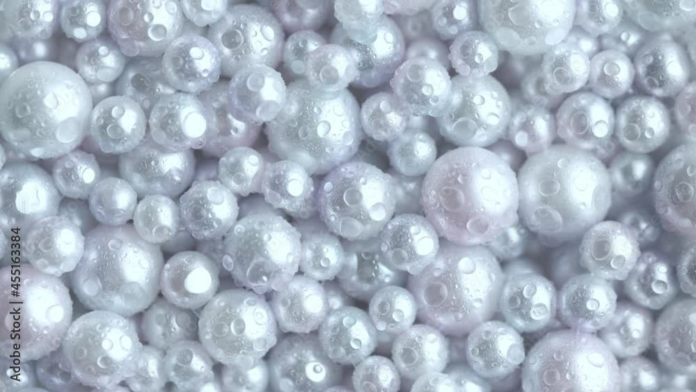 Beautiful background with mother-of-pearl white pearls, top view. Rotation in a circle. Abstract texture for festive backgrounds. Shiny surface of Christmas decorations. Silver bright background. Beautiful background with mother-of-pearl white pearls, top view. Rotation in a circle. Abstract texture for festive backgrounds. Shiny surface of Christmas decorations. Silver bright background.