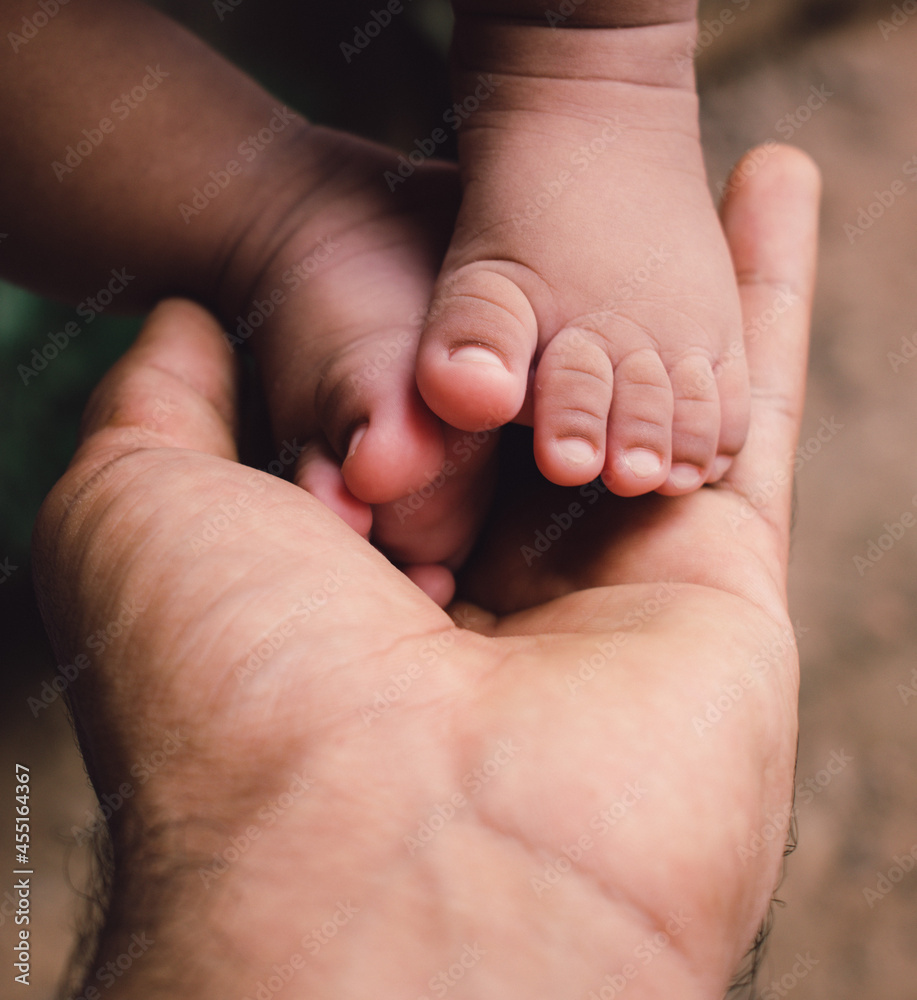 parents holding their son's little foot parents holding their son's little foot