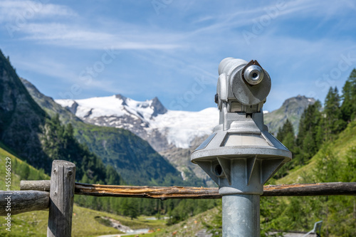 Touristic telescope in alpine valley for watching surrounding mountains and glacier. Grossvenediger lookout point, Hohe Tauern National Park, Austrian Alps