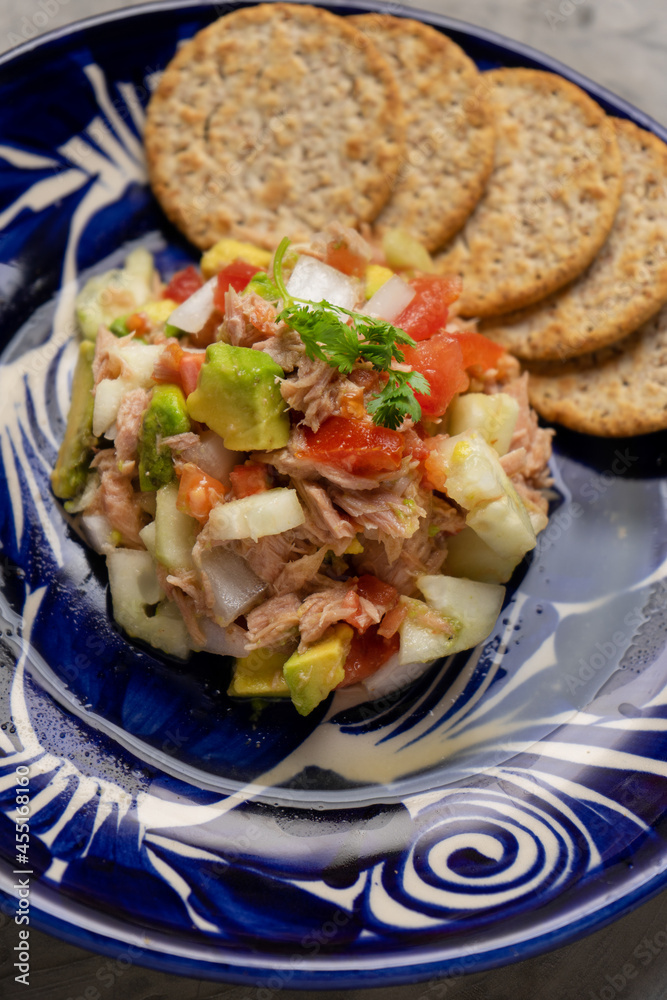 Tuna salad with avocado and cucumber on grey background Tuna salad with avocado and cucumber on grey background