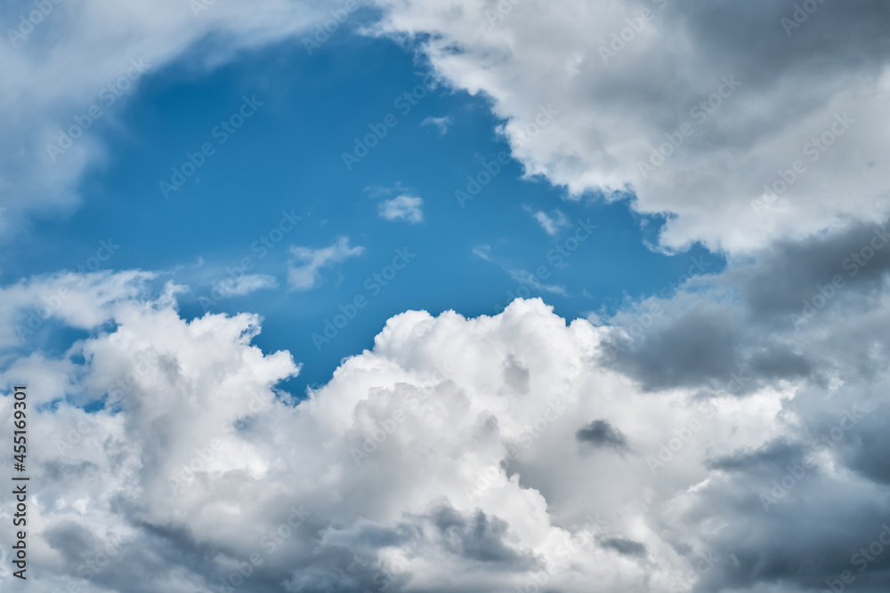 Fluffy storm clouds against the bright blue sky. Nature background. Copy space Fluffy storm clouds against the bright blue sky. Nature background. Copy space