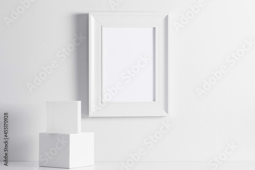 White photo frame mockup on table. Front view. Place for text