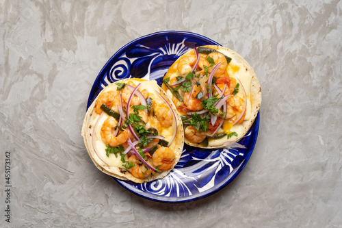 Mexican food. Shrimp tacos with melted cheese and poblano pepper called gobernador on grey background. photo