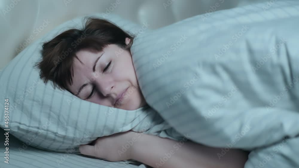 happy brunette woman puts her head on the pillow and falls asleep, at night, cinematic shot happy brunette woman puts her head on the pillow and falls asleep, at night, cinematic shot