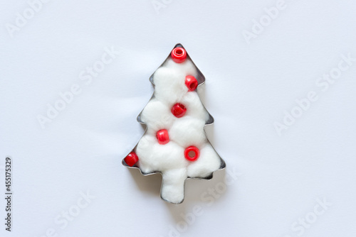 cotton ball and plastic beads christmas tree isolated on a light background