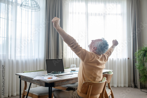 Gray-haired man in casual clothes working from home