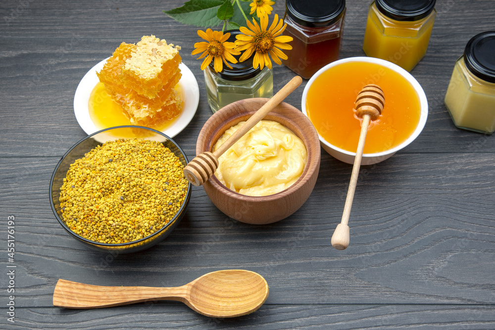 Fresh flower honey of different varieties, pollen and honeycomb with spoons on a wooden background. Organic Vitamin Health Food Fresh flower honey of different varieties, pollen and honeycomb with spoons on a wooden background. Organic Vitamin Health Food