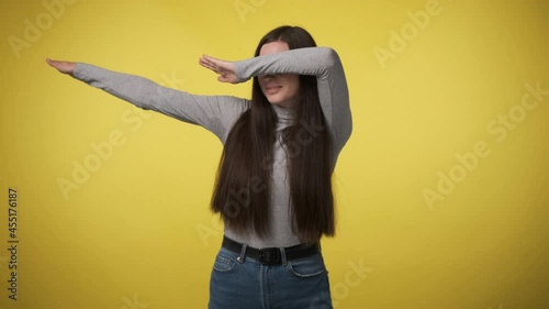 woman in gray turtleneck makes hype movement dab with her hands and covers her face. When you won or did everything right. Yes, I am very cool. photo