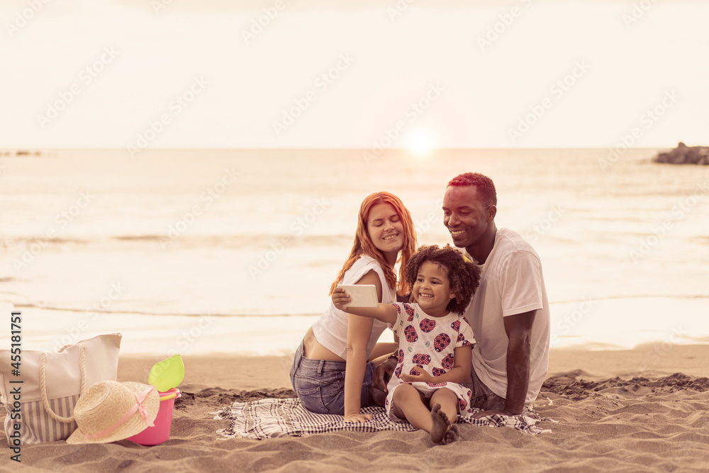 Image of young happy family outdoors at the beach take a selfie by camera. Portrait of multiracial family. Summer, holiday and travel concept. Image of young happy family outdoors at the beach take a selfie by camera. Portrait of multiracial family. Summer, holiday and travel concept.