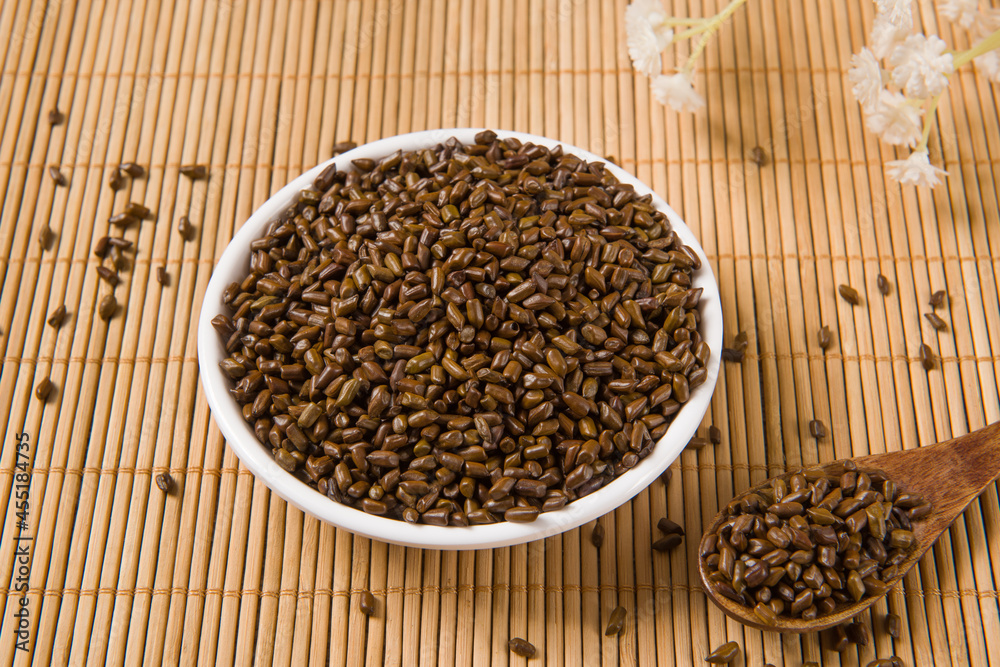 Chinese herbal medicine cassia seeds on wood background Chinese herbal medicine cassia seeds on wood background