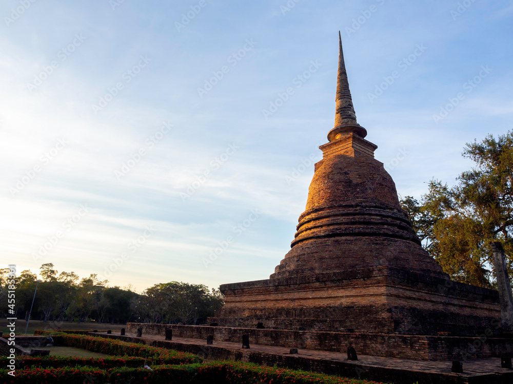 Fototapeta premium Beautiful scene of old ancient pagoda on blue sky background with copy space, at Sukhothai Historical Park, a UNESCO World Heritage Site in Thailand.