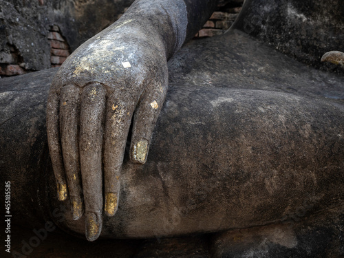 Close-up stucco hand of ancient buddha statue at Wat Sri Chum Temple, the famous landmark in at Sukhothai Historical Park, a UNESCO World Heritage Site in Thailand.