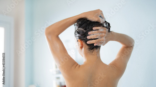 Asian woman She takes a shower and washes her hair in the bathroom