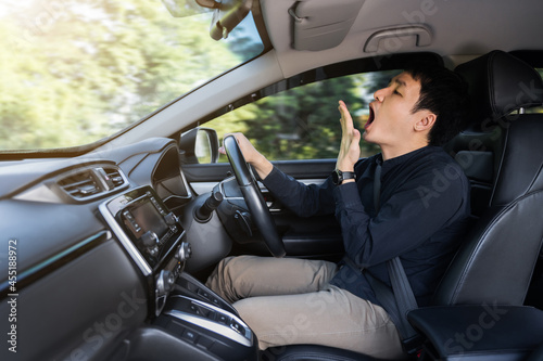 tired man yawning and sleepy while driving car