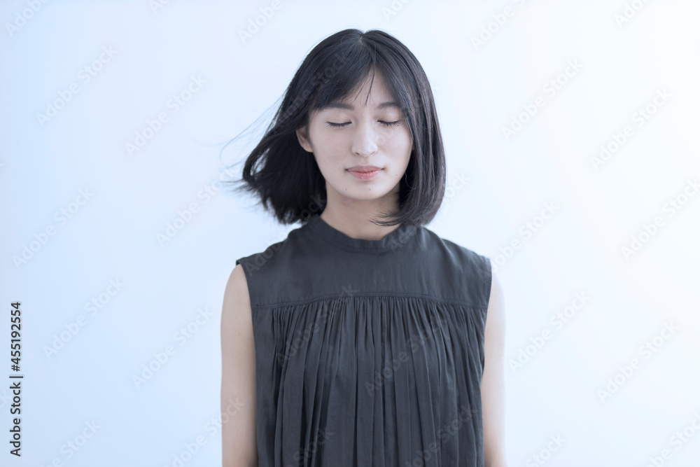 髪をなびかせて目を閉じる若い日本人女性 髪をなびかせて目を閉じる若い日本人女性