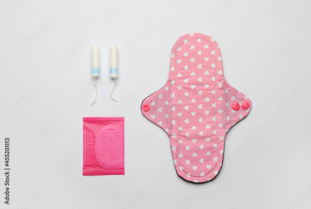 Disposable and reusable menstrual pads near tampons on white background, flat lay Disposable and reusable menstrual pads near tampons on white background, flat lay