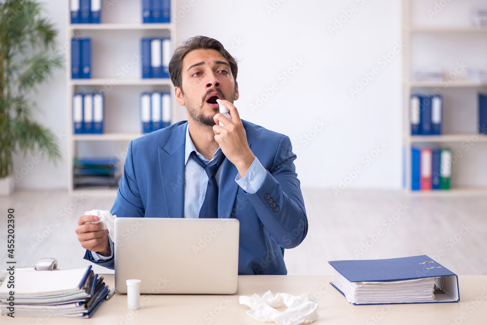 Young male employee suffering at workplace Young male employee suffering at workplace