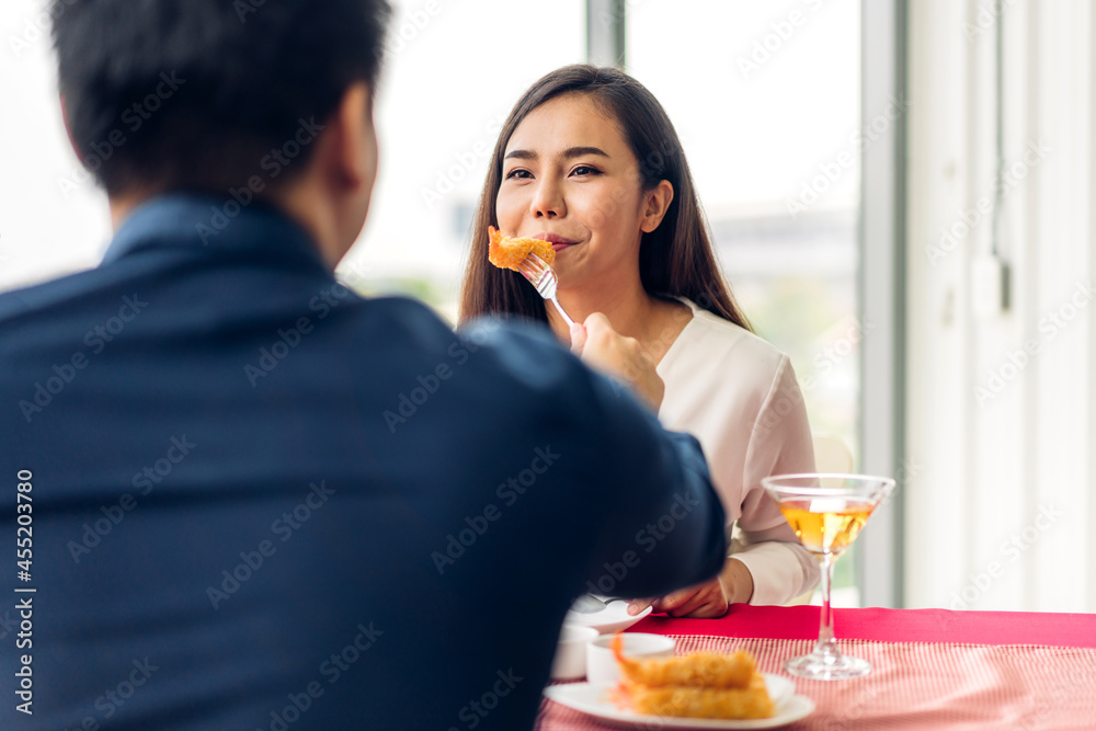 Romantic young asian happy love couple relaxing and talking together eat food and drinking wine glasses celebrating at dinner party lying on chair in the restaurant.date and anniversary concept Romantic young asian happy love couple relaxing and talking together eat food and drinking wine glasses celebrating at dinner party lying on chair in the restaurant.date and anniversary concept