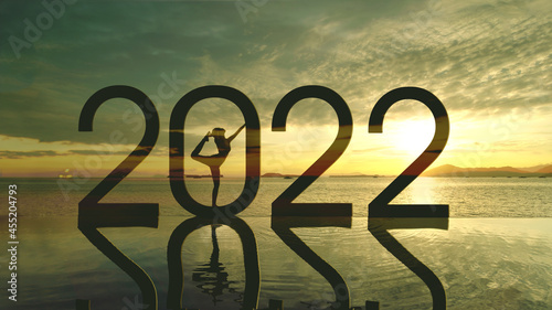 Unknown woman practicing yoga with 2022 numbers