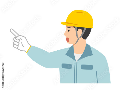 指差し確認をする作業着の若い男性