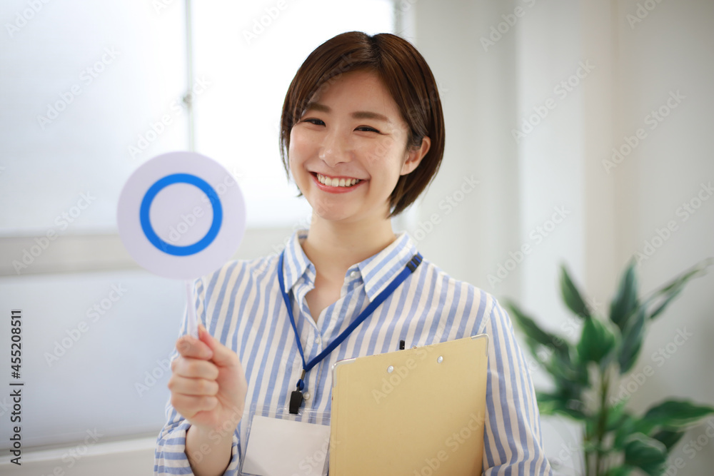 	〇札とバインダーを持つ女性社員