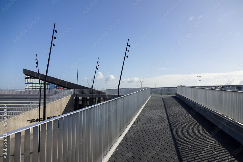 View to the new cruise terminal (Kruiisiterminal) concrete building in the port of Tallinn on a sunny day. Stairs and walkways with paving. Blue clear sky. Estonia, Europe. Sept. 2021