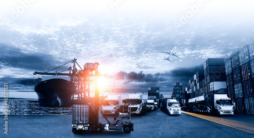 Container truck in ship port for business Logistics and transportation of Container Cargo ship and Cargo plane with working crane bridge in shipyard with blue tone