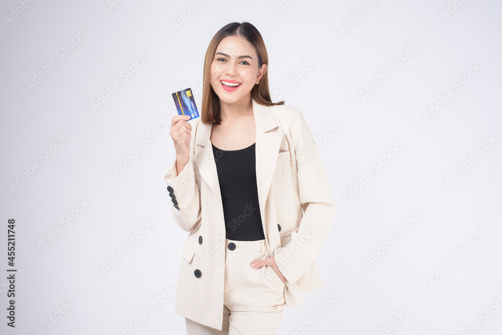 Portrait of Young beautiful woman in suit holding credit card over white background in studio. Portrait of Young beautiful woman in suit holding credit card over white background in studio.