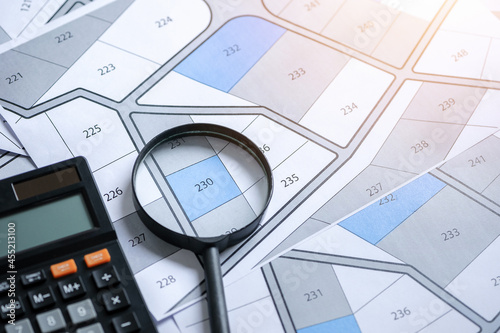 calculator with magnifier on cadastre map search for assess to buy the land concept with copy space