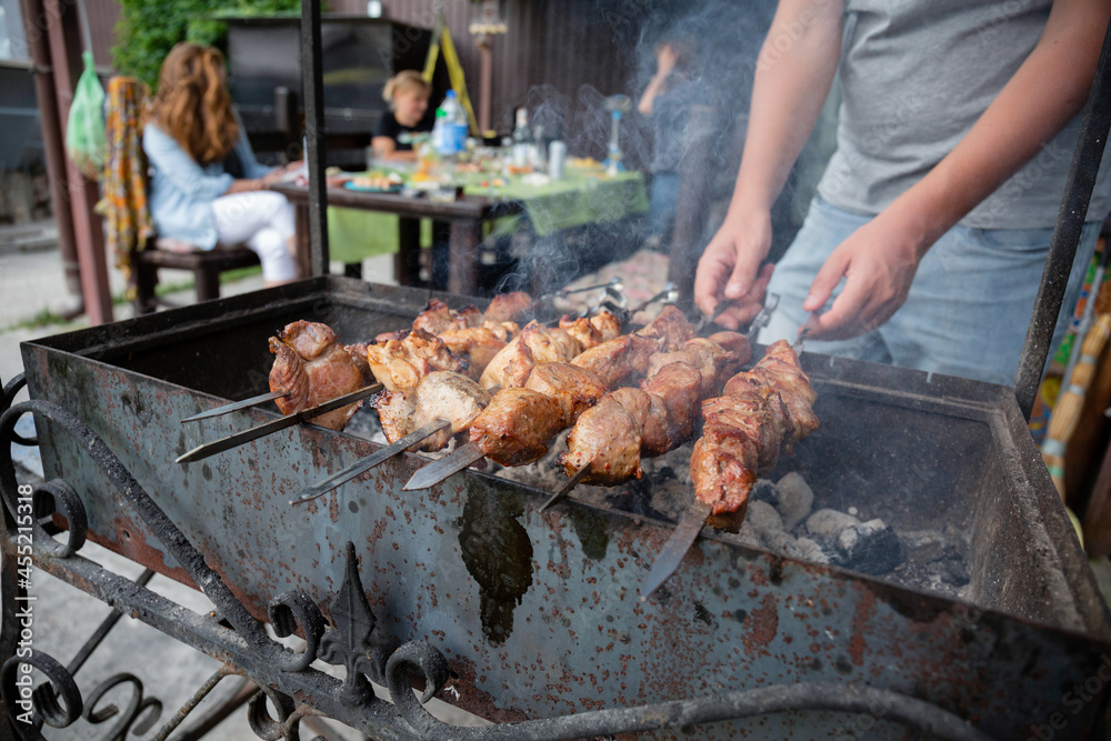 A man grills meat kebabs
