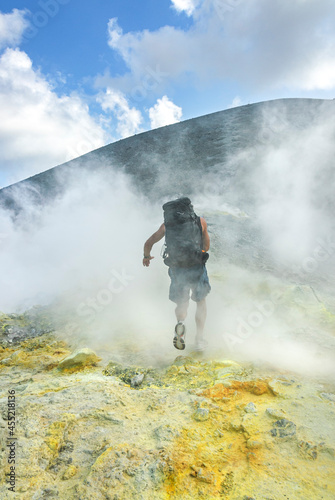 Wanderer durchquert Schwefeldampfwolken am Krater des Vulcano 
