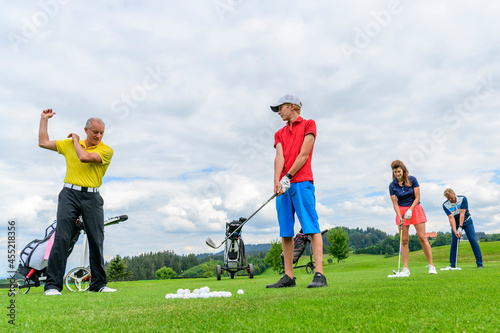 Golf-Schüler beim Training mit Pro auf der Driving-Range