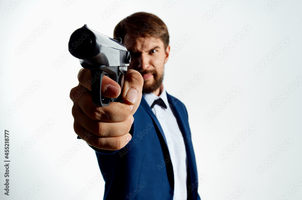 Man gun in the hands of the mafia emotions Agent light background Man gun in the hands of the mafia emotions Agent light background