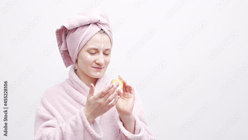 Attractive woman in head towel and bathrobe Applying moisturizing skin cream. Attractive woman in head towel and bathrobe Applying moisturizing skin cream.