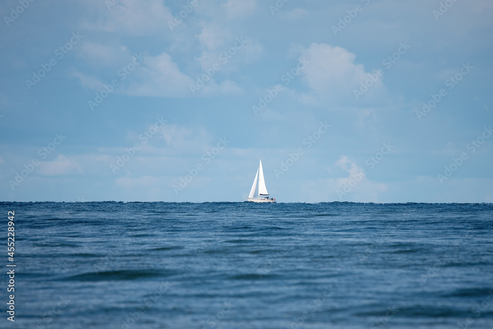 White yacht on horizon in Baltic sea.