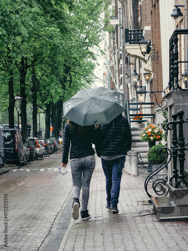 Photography Young couple walks the old streets of Amsterdam in the rain