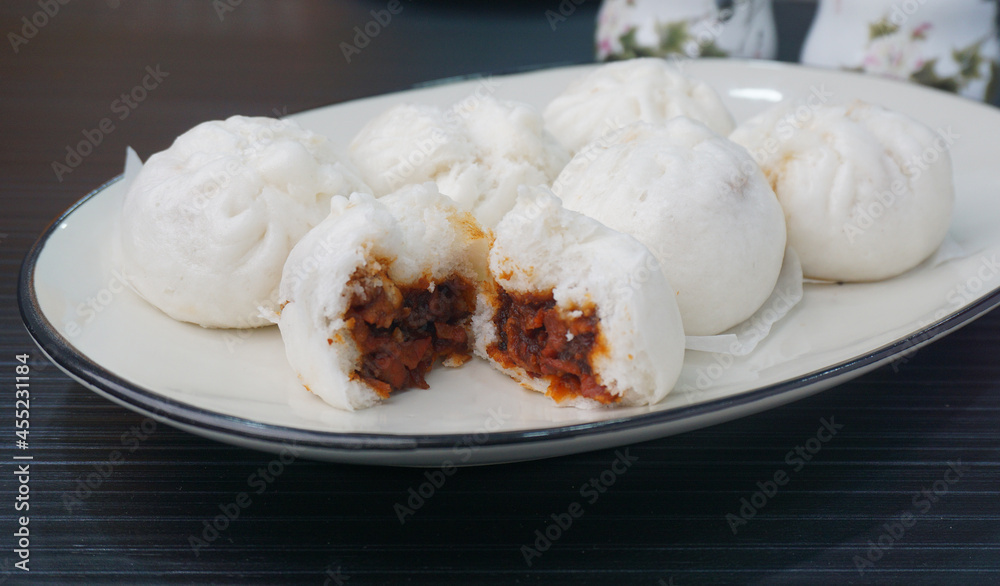 steamed fresh char stew marinated pork belly bun white baozi on dark grey wood background Hong Kong dim sum menu steamed fresh char stew marinated pork belly bun white baozi on dark grey wood background Hong Kong dim sum menu