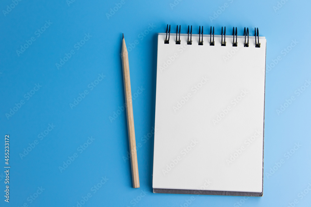 Top view of note and pencil on blue background. space to copy Top view of note and pencil on blue background. space to copy