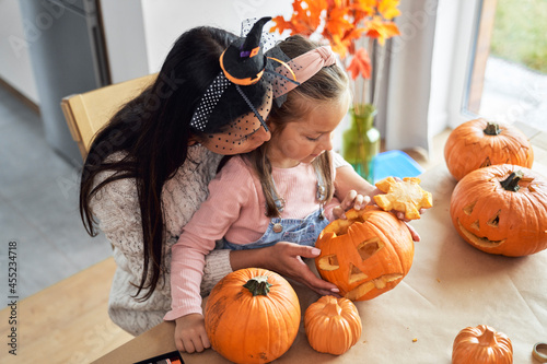 Mom with little girl making pumpkins for Halloween