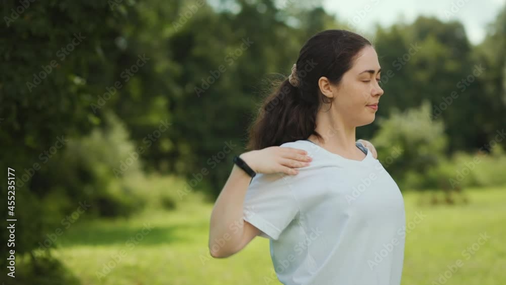 Outdoors warmup. Portrait of young beautiful woman doing warm-ups in the park. Slow motion. Sport and wellness. Outdoors warmup. Portrait of young beautiful woman doing warm-ups in the park. Slow motion. Sport and wellness.