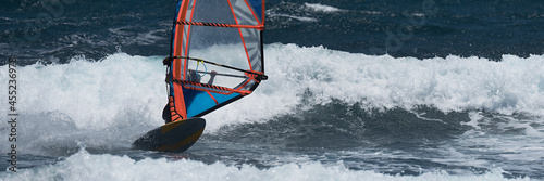 Windsurfer surfing the wind on waves in ocean sea