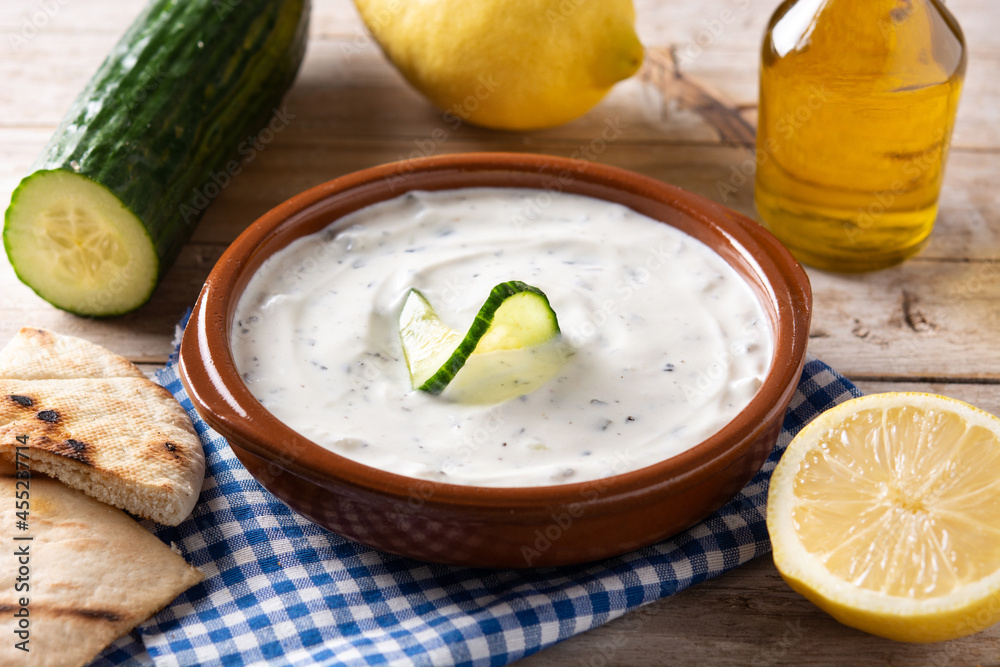 Traditional Greek Tzatziki on rustic wooden table Traditional Greek Tzatziki on rustic wooden table