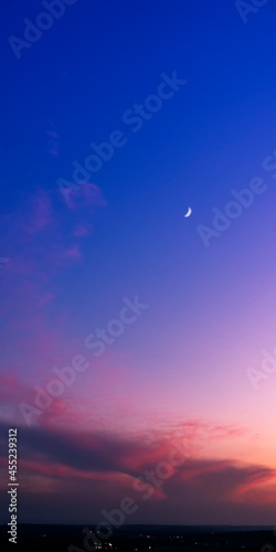 Crescent moon and stars above just after sunset.