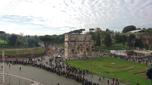 Photography High angle shot of a long queue of people at the Arch of Constantine in Rome