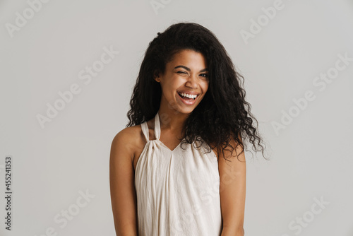 Black young woman in dress smiling and wink at camera