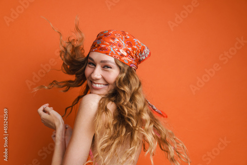 Young ginger woman wearing bandana making fun with her hair photo