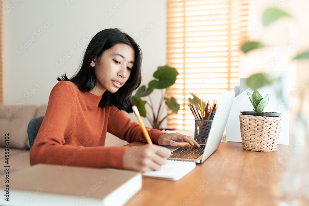 Asian girl student doing homework and learning online with a tutor on laptop Asian girl student doing homework and learning online with a tutor on laptop