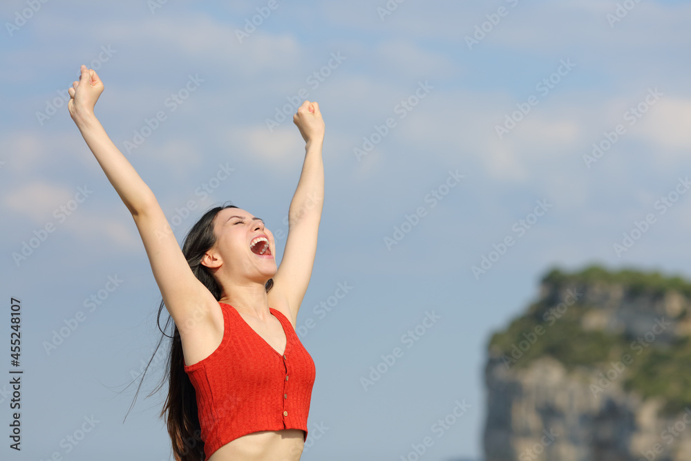 Excited asian woman raising arms in nature Excited asian woman raising arms in nature